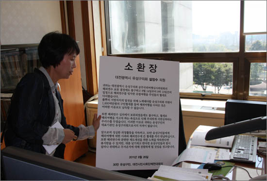 기자회견을 마치 대전시민사회단체연대회의 고은아 상임운영위원장이 자리를 비운 설장수(한나라당)의원의 의자에 '소환장'을 올려 놓고 있다.