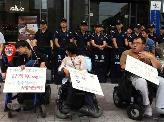 기자회견을 마친 장애인들이 나경원 의원실앞으로 이동해 항의서한 전달을 시도하는 모습과 사무실앞에 배치된 경찰들.
