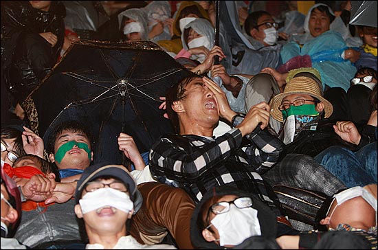 29일 오후 서울 중구 을지로입구역 사거리에서 경찰들이 도로 점거시위를 벌이는 학생들에게 물대포(살수차)를 발사하자, 학생들이 반값등록금 실현을 요구하며 울부짖고 있다.