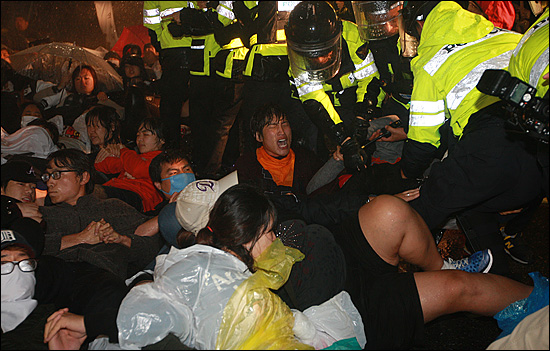 30일 새벽 서울 중구 을지로입구역 사거리에서 경찰들이 반값등록금 실현을 촉구하며 도로 점거시위를 벌이는 학생들에게 물대포(살수차)를 발사하며 강제연행하고 있다.