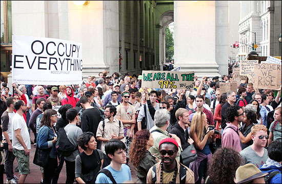 타락한 금융자본주의와 경제적 불평등에 항의하면서 시작된 미국 뉴욕 월스트리트 점거 시위가 장기화 양상을 보이고 있다. 점거 시위 첫날 수백명에 불과했던 시위대는 14일이 지난 9월 30일(현지 시각) 2000여명으로 급격히 불어났다. 이날 시위대는 월스트리트 인근 시위 캠프(자유광장)에서 뉴욕시 경찰청 앞까지 행진하며 "나치 은행가들", "거리는 우리의 것", "우리는 99%", "경찰은 '월스트리트 점령'에서 손을 떼라", "(월스트리트 점령)이 모든 것" 등의 구호를 외쳤다. 사진은 뉴욕시 경찰청 앞마당으로 진입하는 시위대의 모습.  