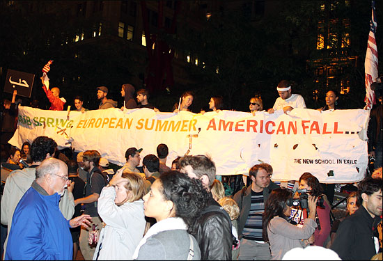 지난 5일(현지 시간) 오후 로어 맨해튼 폴리스퀘어에 1만5000여 명의 시위대가 모여 뉴욕증권거래소 인근 자유광장(주코티파크)까지 행진했다. 시위대가 '이집트는 봄, 유럽은 여름, 미국은 가을'이라고 적힌 펼침막을 들어보이고 있다. 월스트리트 점령 운동은 '아랍의 봄'에서 기인했다는 것이 이들의 주장이다. 
