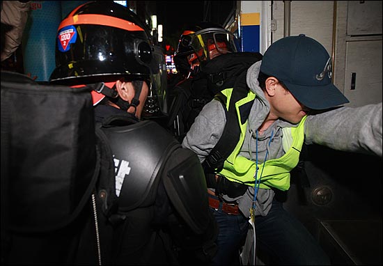 8일 오후 부산 중구 남포동에서 한 인권감시자가 희망버스 참가자들의 강제연행에 항의하며 실랑이를 벌이자, 경찰들이 강제연행하고 있다.