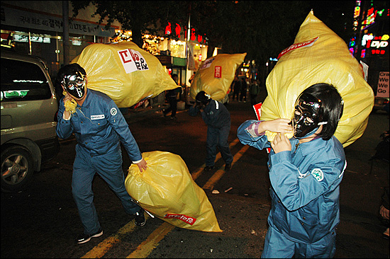  중앙노동위원회는 한진중공업 해고자들의 부당해고 구제신청과 관련해 심판을 내리지 않고 교섭을 하라며 권고안을 제시했다. 사진은 5차 희망버스 행사 때 한진중공업 노동자 복장을 한 사람들이 남포동 거리에서 '정리해고와 비정규직'의 고된 삶을 표현하고 있다.