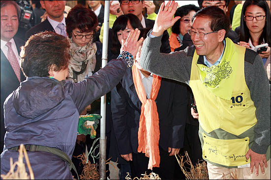  14일 오후 경동시장을 방문한 박원순 야권통합 서울시장 후보가 인사를 주고받은 한 상인과 하이파이브를 하고 있다.