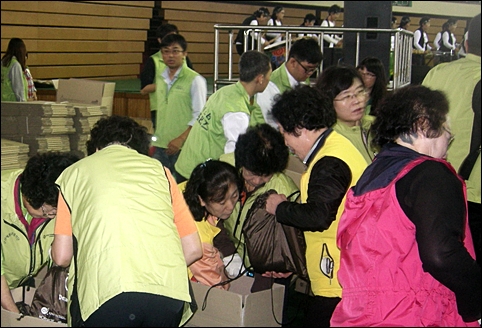 자원봉사자들이 식량이 담긴 상자를 옮기고 있습니다.
