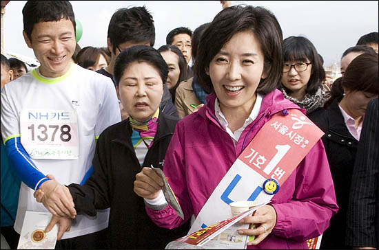 나경원 한나라당 서울시장 후보가 16일 오전 여의도 마라톤대회 참가자들과 인사하며 홍삼액을 선물받고 있다.