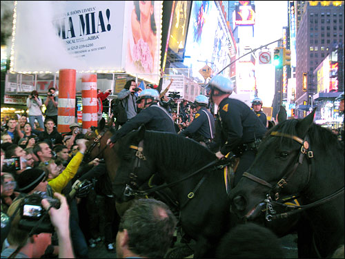 '월스트리트 점령' 시위대가 지난해 10월 15일 뉴욕 맨해튼 타임스퀘어에 모여 시위를 벌인 가운데, 뉴욕 기마경찰이 시위대를 밀어내기 위해 시위대를 향해 말을 몰고 가서 위협하고 있다.