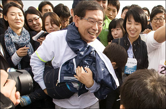 박원순 야권통합 서울시장 후보가 16일 오전 여의도 마라톤대회에서 만난 한 어린아이를 껴안아 번쩍 들어올리고 있다.