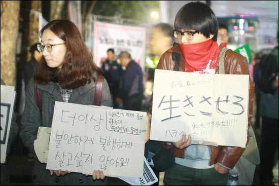 중간고사 기간임에도 집회에 참석한 대학생들이 청년들의 아픔을 표현한 피켓을 들고 있다.