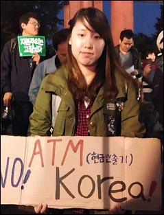 이미림씨가 15일 서울 덕수궁 대한문 앞에서 열린 '서울을 점령하라' 집회에서 손팻말을 들고 서 있다.