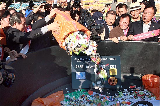 18일 오후 서울 잠실종합운동장에서 열린 '범외식인 10만인 결의대회'에서 외식업 경영자들이 카드사들의 신용카드수수료율 1.5% 이하 인하를 촉구하며 솥단지에 신용카드를 버리는 퍼포먼스를 벌이고 있다.