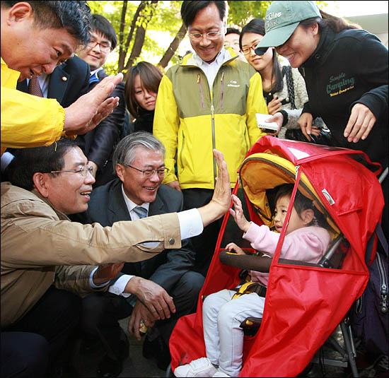 18일 문재인 노무현재단 이사장과 거리유세에 나선 박원순 야권통합 서울시장 후보가 길을 지나던 한 어린아이와 하이파이브를 하며 환하게 웃고 있다.