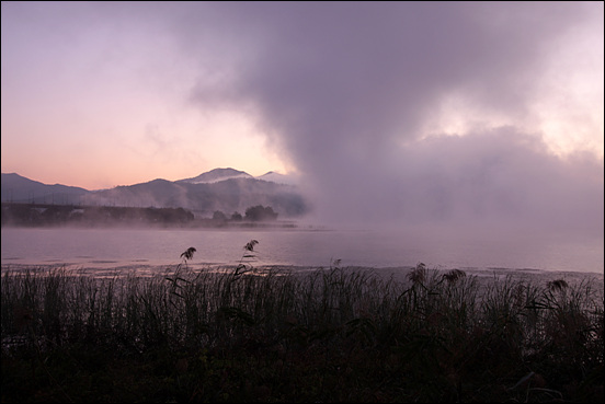 이른 아침, 북한강과 남한강이 만나는 두물머리에 물안개가 피어오르고 있다.