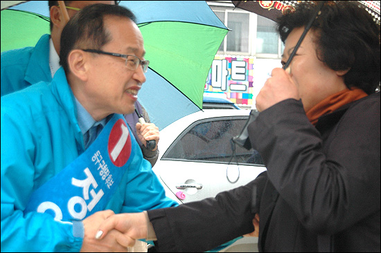  10.26 부산 동구청장 재선거에 나선 한나라당 정영석 후보가 22일 거리 유세 도중에 시민들과 인사를 나누고 있다.