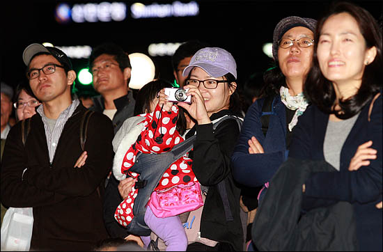23일 저녁 광화문 광장에서 박원순 야권통합 서울시장 후보의 거리유세를 지켜보던 한 시민이 디카를 꺼내 아이와 함께 박 후보를 찍고 있다.