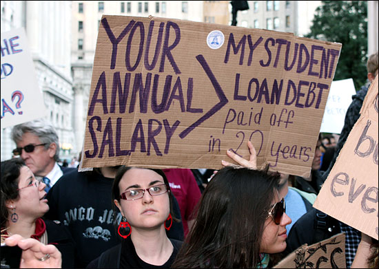 '월스트리트 점령' 시위대 중 한 학생이 "당신(1%)의 연봉이 20년 동안 갚아야 할 나의 학자금 대출보다 많다"는 내용의 손팻말을 들고 뉴욕 맨해튼 거리를 행진하고 있다. 