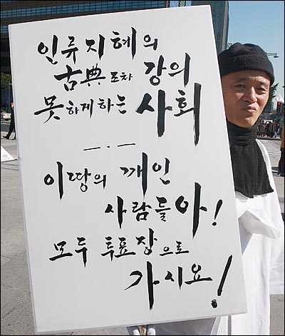 도올 김용옥 원광대 석좌교수가 지난해 10월 26일 오전 서울 광화문 광장 이순신 동상 앞에서 투표 참여를 독려하는 1인 시위를 벌이고 있다.(자료 사진)