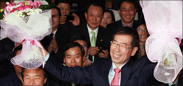 박원순 서울시장 당선자가 27일 새벽 안국동 선거캠프에서 승리를 자축하며 꽃다발을 받아들고 있다.