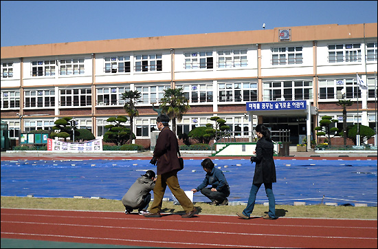  경상남도교육청은 석면이 검출된 밀주초등학교 ‘감람석 운동장’에 대해 철거 작업에 들어간다. 사진은 시공 업체에 대한 법적 대응을 위해 시료를 채취하는 모습.
