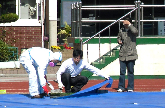  경상남도교육청은 석면이 검출된 밀주초등학교 ‘감람석 운동장’에 대해 철거 작업에 들어간다. 사진은 법적 절차를 밟기 위해 증거보전용으로 시료를 채취하는 모습.
