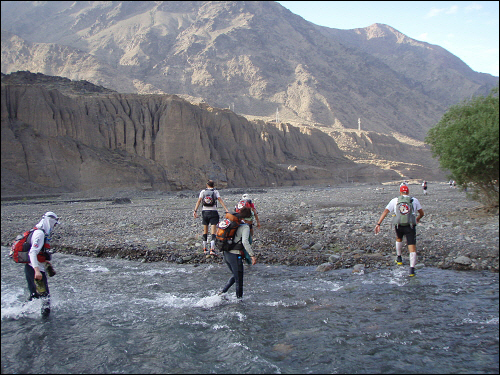  협곡을 흐르는 차가운 강물을 건너는 참가자들