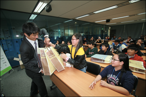 지난 10월 <오마이뉴스> 사무실을 방문한 더불어 졸업식 참가 학생들이 교육전문기업 비상교육이 제공한 책들을 선물로 받고 있다
