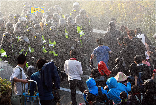 한미FTA 비준안 강행처리를 막기 위해 3일 오후 국회 진입을 시도하던 시위대가 경찰과 대치하다 물대포를 맞고 있다.