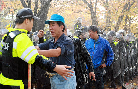 한미FTA 비준안 강행처리를 막기 위해 3일 오후 국회 진입을 시도하던 시위대가 물대포를 쏘며 막아 선 경찰에게 항의하고 있다.