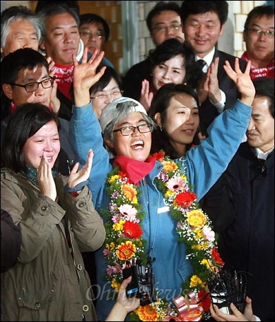 정리해고 철회를 요구하며 309일간 한진중공업 '85호 크레인'에서 고공농성을 벌인 김진숙 민주노총 부산본부 지도위원이 10일 오후 노사잠정합의안이 노조 총회에서 만장일치로 가결된 뒤 사수대로 137일간 함께 농성을 벌인 해고노동자 3명과 함께 크레인에서 내려왔다. 한진중공업 본관앞에서 기자회견을 연 김 지도위원이 "웃으면서, 끝까지, 함께, 투쟁!"을 외친 뒤 손을 흔들며 활짝 웃고 있다.