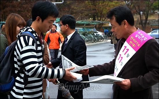  진주농민회와 경상대 총학생회는 11일 오전 경상대 중앙도서관 앞에서 '가래떡데이' 행사를 열고 학생들에게 500인 분량의 떡을 나눠주었다. 사진은 강병기 전 경남도 정무부지사가 학생들에게 홍보전단을 나눠주는 모습.