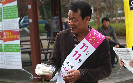  진주농민회와 경상대 총학생회는 11일 오전 경상대 중앙도서관 앞에서 '가래떡데이' 행사를 열고 학생들에게 500인 분량의 떡을 나눠주었다. 사진은 가래떡을 나눠주는 강병기 전 경남도 정무부지사의 모습.