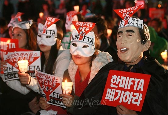  13일 오후 서울광장에서 열린 '한미FTA 저지' 촛불집회에 참석한 <나는 꼼수다>(나꼼수)의 정봉주 전 의원 팬클럽 '정봉주와 미래권력들' 회원이 이명박 대통령과 고양이 가면을 쓰고 참여하고 있다.