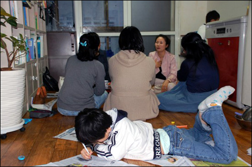 자폐아를 둔 이은진씨, 유순금씨, 김예원씨, 유현옥씨가 이야기를 나누는 동안 수현이가 바닥에 엎드려 그림을 그리고 있다.