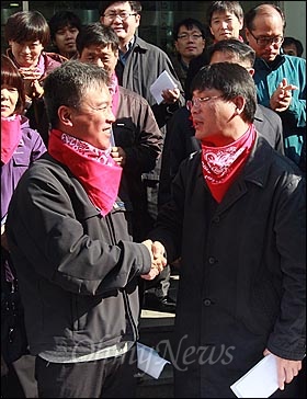  '정리해고·비정규직 없는 세상을 위한 희망의 버스' 기획단 송경동 시인이 15일 오전 서울 중구 정동 민주노총 앞에서 경찰조사에 대한 자진출석에 앞서 '희망의 버스 계획과 경찰수사에 대한 입장 발표 기자회견'을 마친 뒤 김영훈 민주노총 위원장의 격려를 받으며 악수를 나누고 있다.