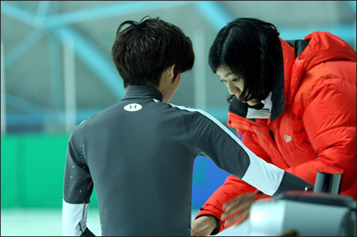  훈련 중인 김민석 선수가 지현정 코치의 지도를 받고 있다