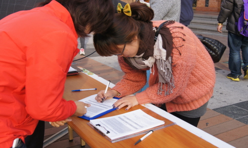  '친환경 의무급식 조례' 제정을 위한 서명운동에 시민들이 서명하고 있다.