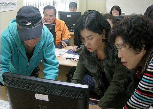 컴퓨터 교실에서 어르신들에게 사용법을 알려주는 박수진 사무국장 
