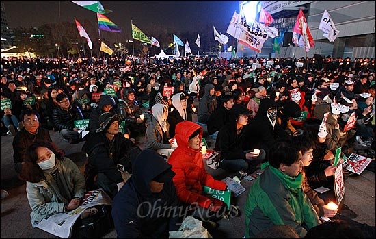 19일 오후 서울 중구 서울광장에서 열린 '한미FTA 저지 범국민 촛불대회'에 참석한 시민들이 국회의 한미FTA 비준안 강행처리 중단을 촉구하고 있다.