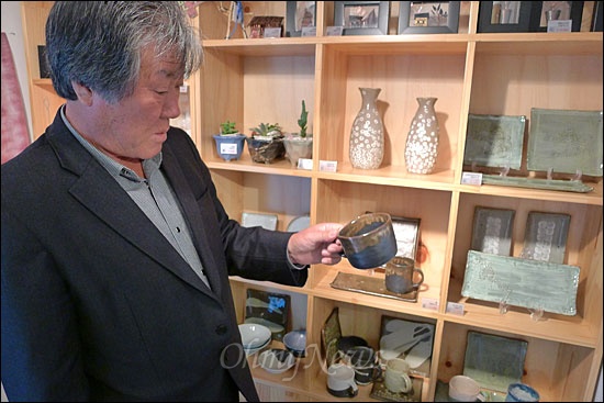 마을 주민 김문생씨가 주민들이 만든 컵을 들여다 보고 있다. 이 마을은 관광객들을 상대로 기념품을 팔아 수익을 창출하고 있다.