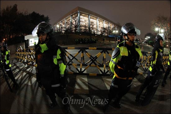  22일 오후 한나라당이 '한미FTA' 비준안을 기습 강행처리한 가운데 진압복을 차려입은 경찰병력이 바리케이트가 쳐진 국회 북문앞에 배치되어 시민들의 출입을 통제하고 있다.