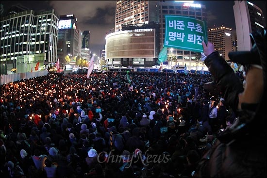 23일 오후 서울광장에서 열린 한미FTA 날치기 처리 규탄 촛불집회에서 시민들이 촛불을 들고 "비준 무효! 명박 퇴진!" 구호를 외치고 있다.