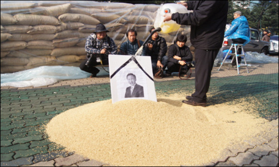 농민들이 한미FTA 비준 철회 집회에서 'MB영정'이 꽂힌 나락 위에 시너를 붓고 있다.