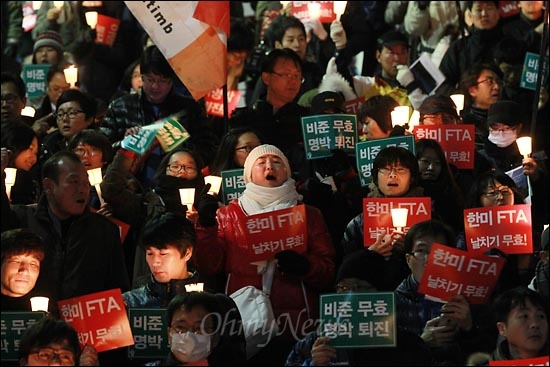 26일 오후 한미FTA 날치기 비준안 처리에 항의하는 야5당 합동 정당연설회와 촛불집회가 예정된 서울 광화문 광장을 경찰이 원천봉쇄한 가운데 광장에 들어가지 못하고 세종문화회관앞 계단에 모인 시민들이 촛불을 들고 구호를 외치고 있다.