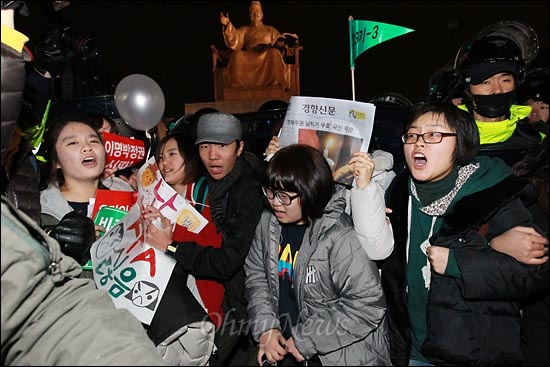  26일 오후 한미FTA 날치기 비준안 처리에 항의하는 야5당 합동 정당연설회와 촛불집회가 예정된 서울 광화문 광장을 경찰이 원천봉쇄한 가운데, 세종문화회관앞에서 열린 촛불집회 뒤 기습적으로 광장에 진입한 시민들이 세종대왕동상앞에서 "명박 퇴진! 비준 무효!"구호를 외치고 있다.