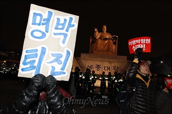 26일 오후 한미FTA 날치기 비준안 처리에 항의하는 야5당 합동 정당연설회와 촛불집회가 예정된 서울 광화문 광장을 경찰이 원천봉쇄한 가운데, 세종문화회관앞에서 열린 촛불집회 뒤 기습적으로 광장에 진입한 시민들이 세종대왕동상앞에서 "명박 퇴진! 비준 무효!"구호를 외치고 있다.