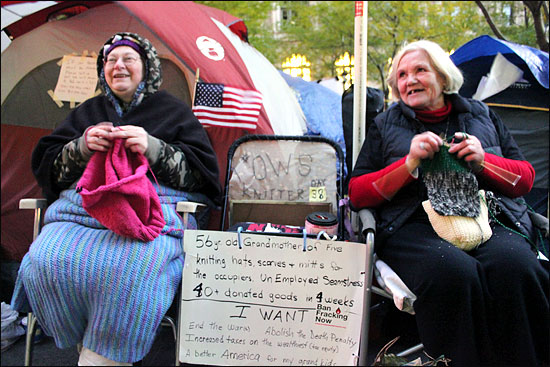 마샤 스펜서(56.왼쪽)씨와 캐런 하프만(69)씨가 자유광장(주코티공원)에서 '월스트리트 점령' 시위대에게 줄 털장갑, 털모자, 털목도리 등을 만들기 위해 뜨개질을 하고 있다.

