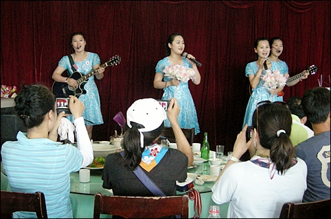  평양 옥류식당 여성 접대원들이 식사를 마치고 음악공연을 하고 있다. (2010년 8월 18일 촬영)
