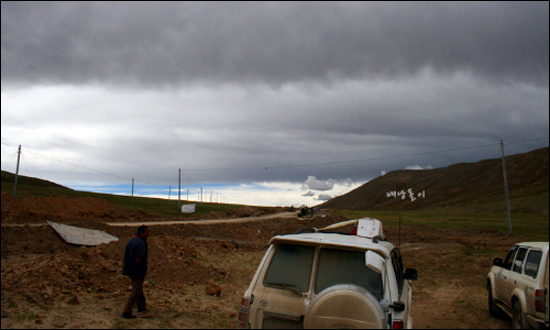 멈추어 선 자동차. 티벳탄 기사가 조심히 주변을 살핀다.