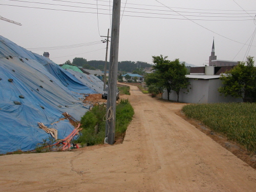 LH아파트 공사차량들은 마을 안길로 드나들며 차재진씨의 집 앞에 산더미처럼 높게 흙더미를 쌓았다.
